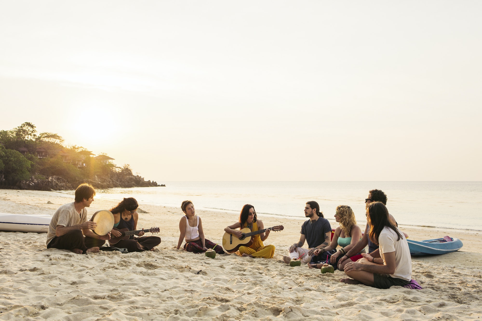 Thailand, Koh Phangan, group of people sitting on a beach with guitar at sunset