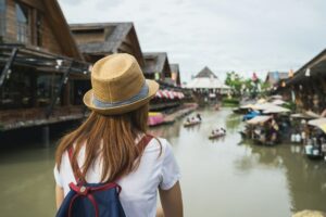 Young woman travel at floating market in Thailand
